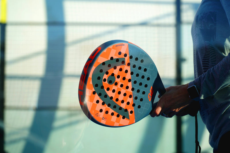 Padel player wearing nasal strip during intense rally on indoor glass court
