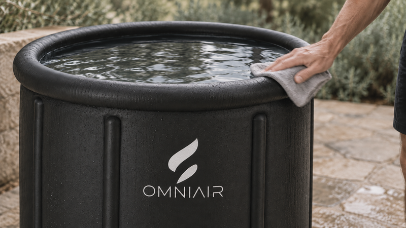 Cleaning the rounded rim of an OMNIAIR ice bath with a soft cloth.